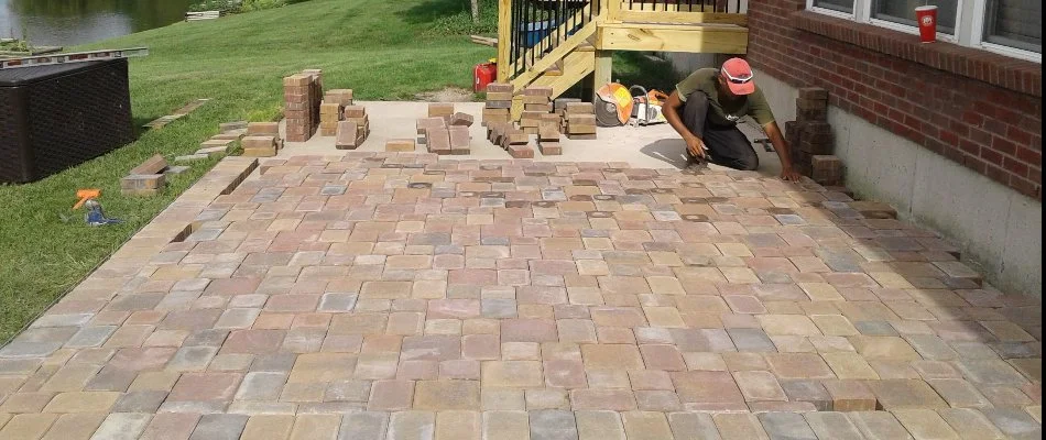 A worker installing pavers for a patio project in Sixteen Mile Stand, OH.