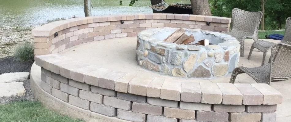 Wood-burning fire pit surrounded by a seating wall. 