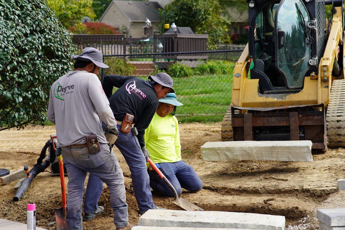 men men installing stone stairs in a backyard